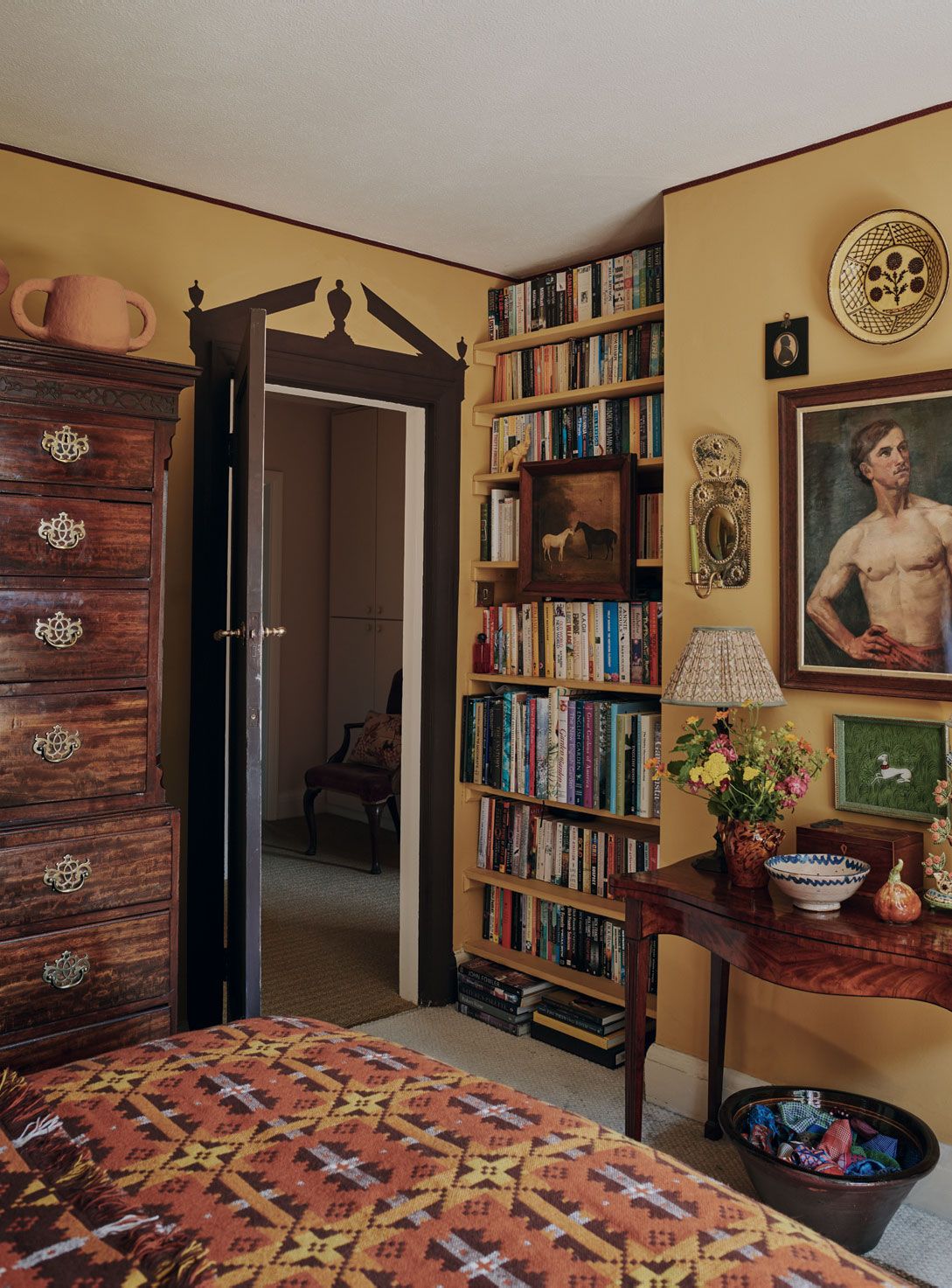 Image may contain Chair Furniture Desk Table Art Painting Adult Person Bookcase Bed Indoors and Interior Design